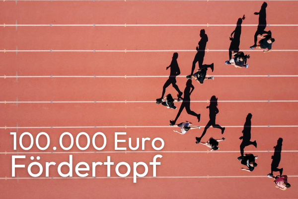 Drohnenaufnahme einer Laufbahn, auf der 8 Personen so in Formation laufen, dass sie eine Pfeilspitze bilden.