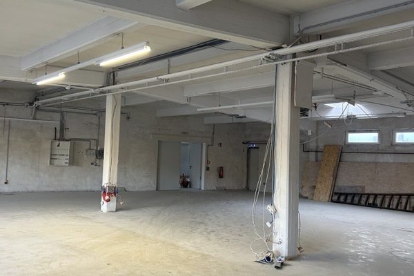 Das Foto zeigt den Ausschnitt einer großen Halle, die sich aktuell in in einem rohen Zustand befindet, da Abrissarbeiten vorgenommen wurden.